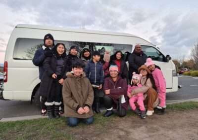Group of people in winter clothes near a tour van