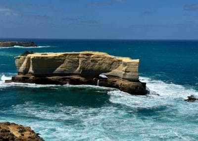 Natural rock arch over turquoise ocean water